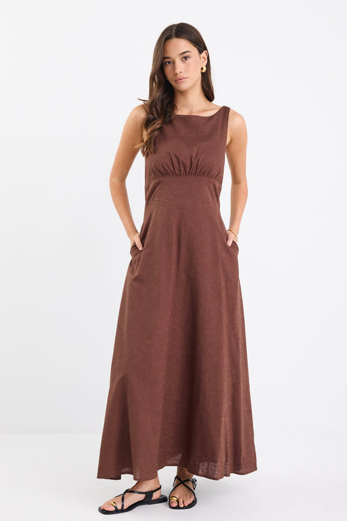 A chocolate brown dress with strappy sleeves and a shirred back for a flattering fit. Made from a breathable blend of 45% Linen and 55% Cotton, and fully lined for comfort.