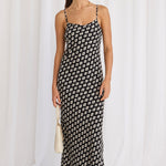 model wears a black print bias maxi dress