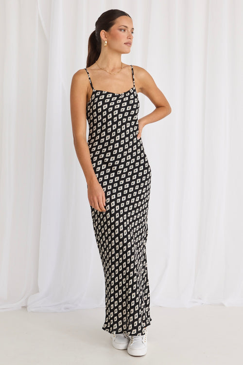 model wears a black print bias maxi dress