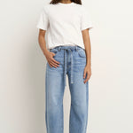 model wears a light blue barrel leg jean with a white t-shirt