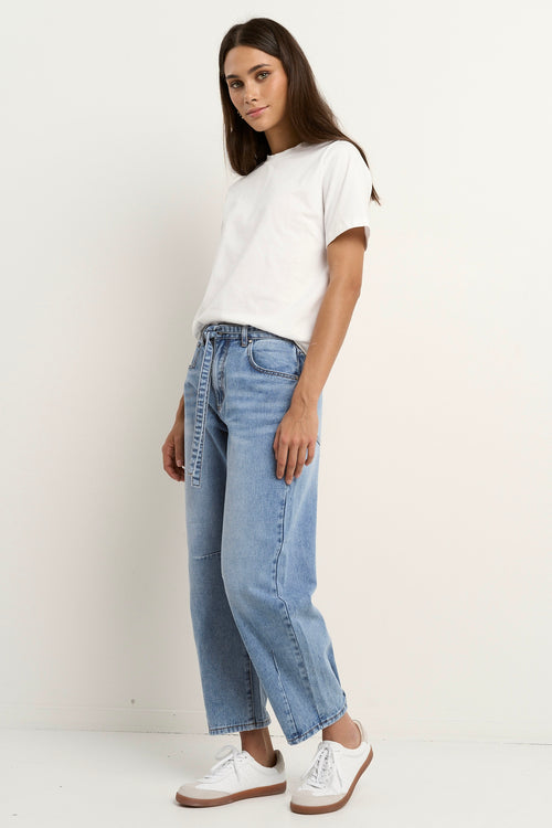 model wears a light blue barrel leg jean with a white t-shirt