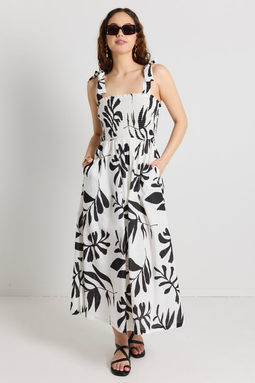 model wears a white and black maxi dress