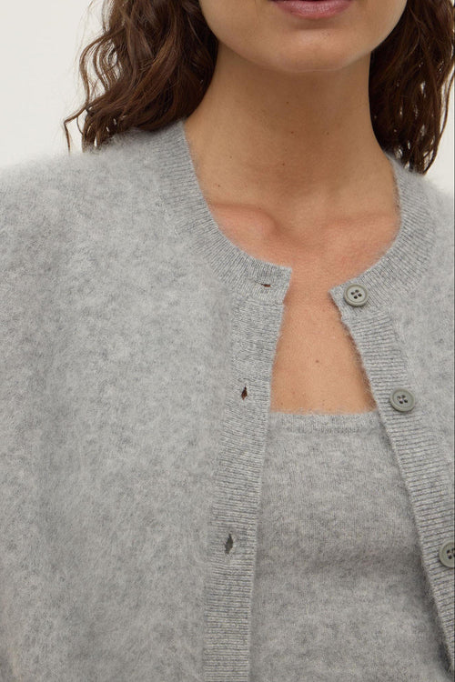 Gray cardigan worn by a person on a white background