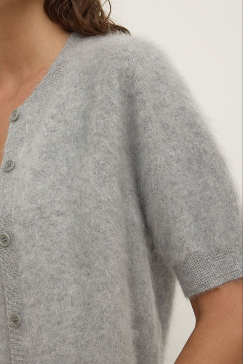 Gray short-sleeve cardigan worn by a person on a white background