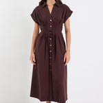 Woman wearing a brown dress with buttons on a white background