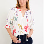 Woman wearing a cream floral poppy top and blue jeans