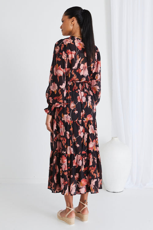 model wears a black floral maxi dress