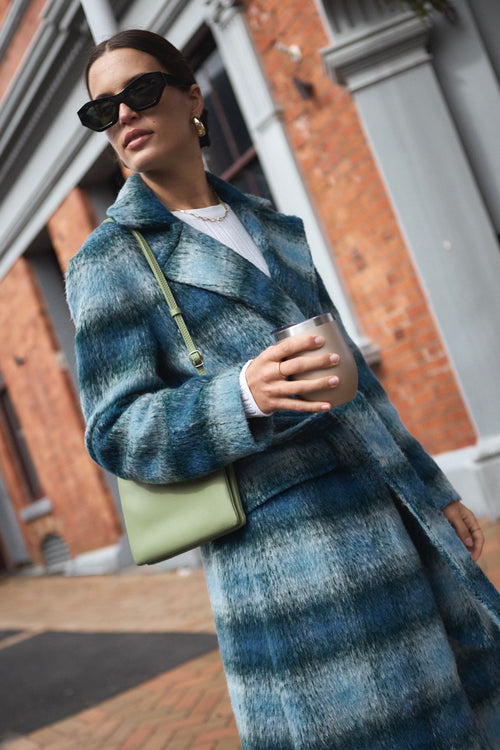 model wears a blue check coat