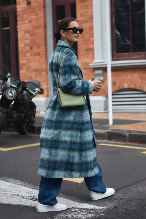 model wears a blue check coat