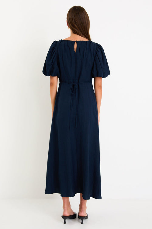 Woman wearing navy blue maxi dress.