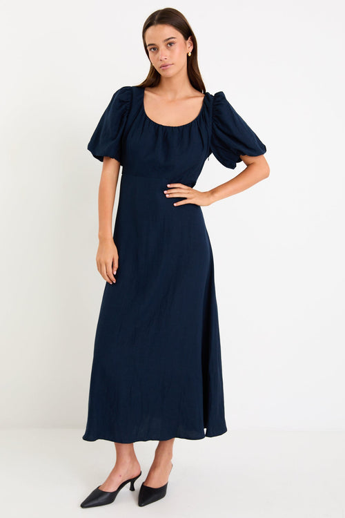 Woman wearing a navy blue dress on a white background