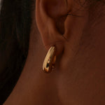 model wearing Chunky Drop Gold Hoop Earrings