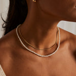 model wearing pearl necklace and gold necklace