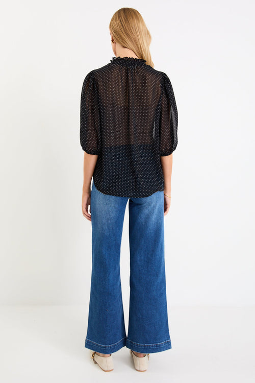 Woman wearing a black white polka dot top
