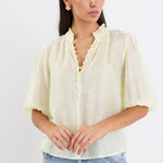 woman wearing yellow sheer blouse with blue jeans