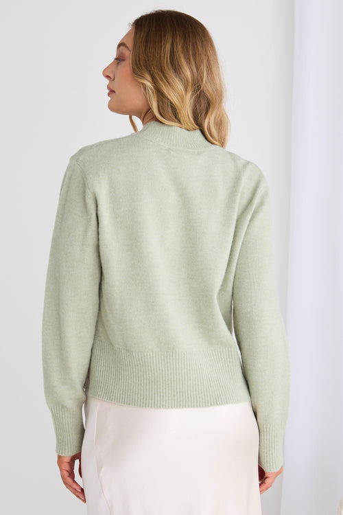 model wears a green knit