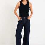 Woman wearing dark denim jean and black singlet