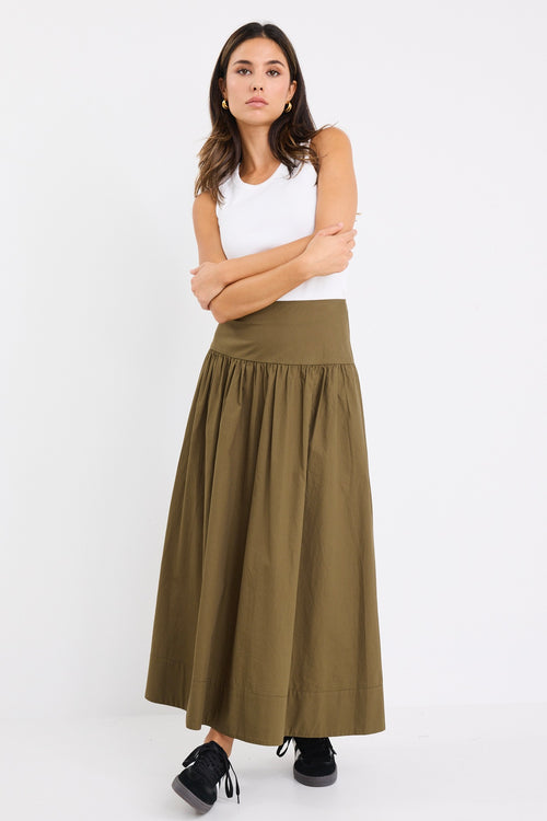 model wears a khaki maxi skirt with a white tank top
