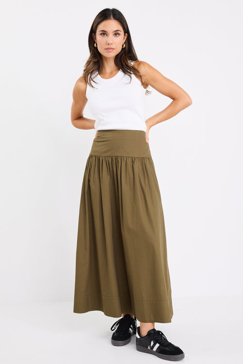 model wears a khaki maxi skirt with a white tank top