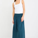 Woman wearing a white top and blue skirt on a white background