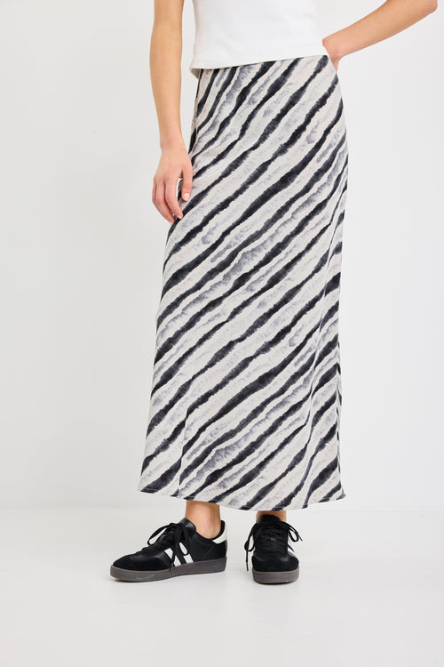 Person wearing a black and white striped skirt on a white background