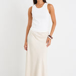 model wears white tank top and a natural linen skirt