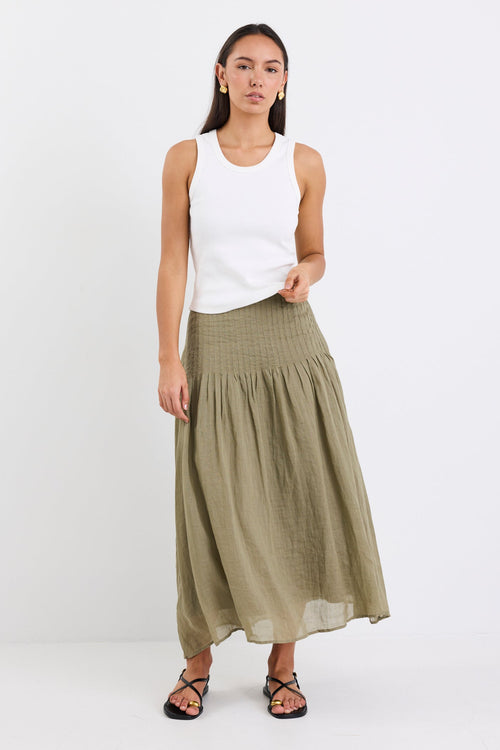 model wearing khaki linen skirt and white top