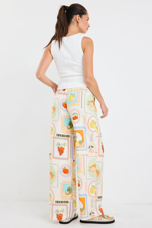 model wears a multi coloured fruit print draw string pant
