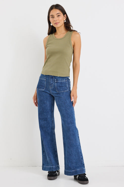 model wears a khaki green ribbed tank top with dark blue jeans