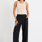 Woman wearing a black pant and beige tank