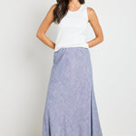 wearing a white ribbed tank top and a blue chambray maxi skirt.