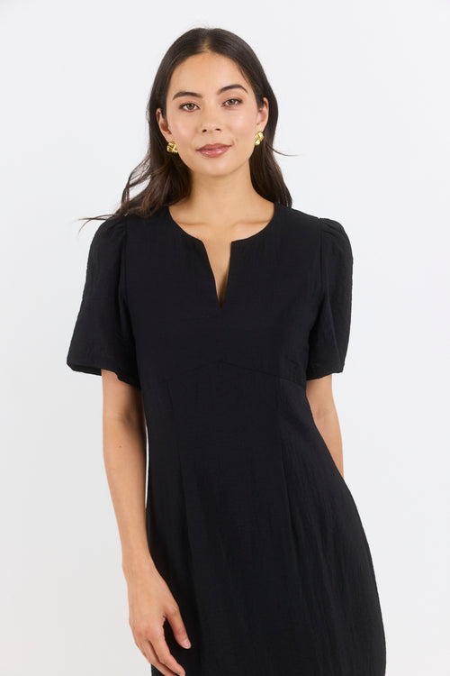 Woman wearing a black dress against a white background