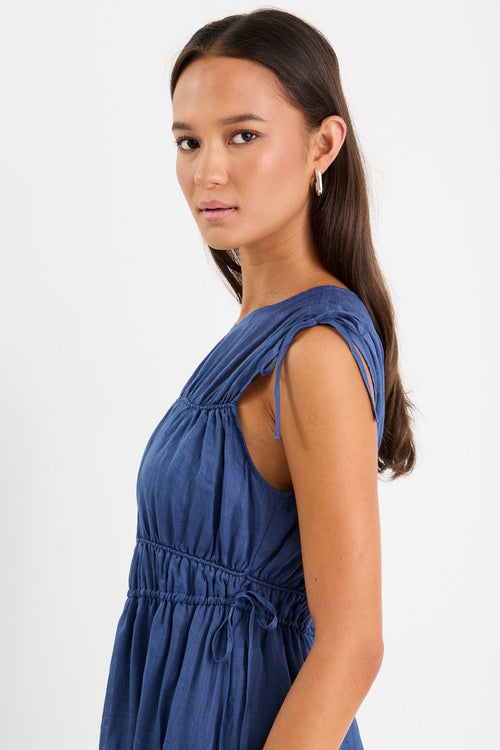 Woman wearing a navy ruched maxi dress