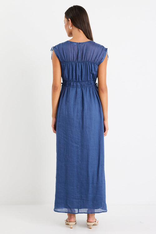 Woman wearing a navy ruched maxi dress
