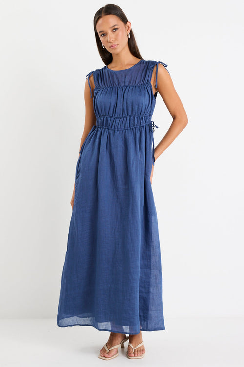 Woman wearing a navy ruched maxi dress
