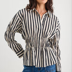 Woman wearing a black and white striped shirt with blue jeans on a white background