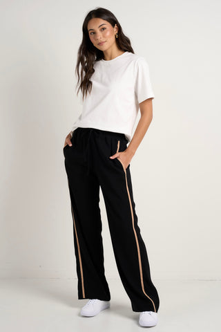 Model wears black track pant