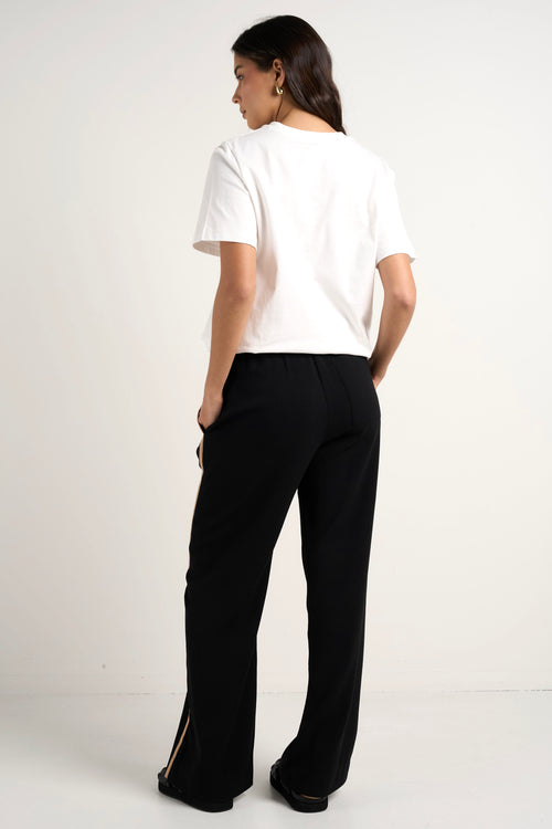 Model wears black track pant