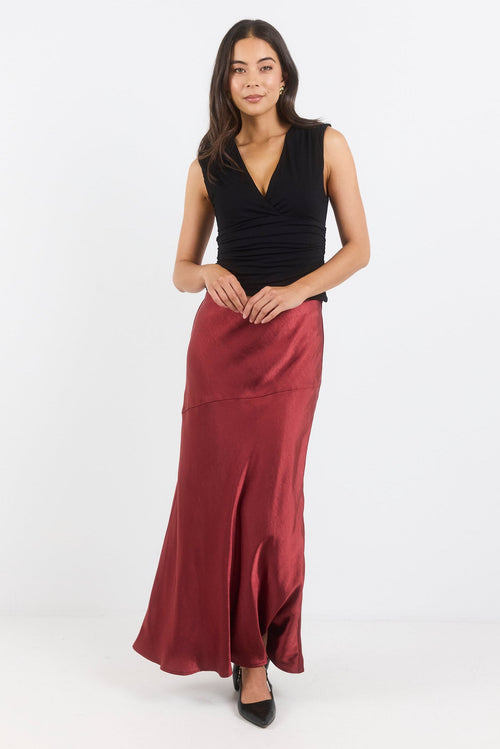 Woman wearing a black top and red skirt on a white background