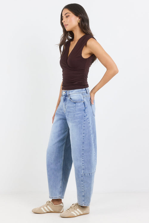 Woman wearing a brown top and light blue jeans on a white background
col_pattern