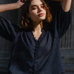 Woman posing with hands behind head against classical architecture