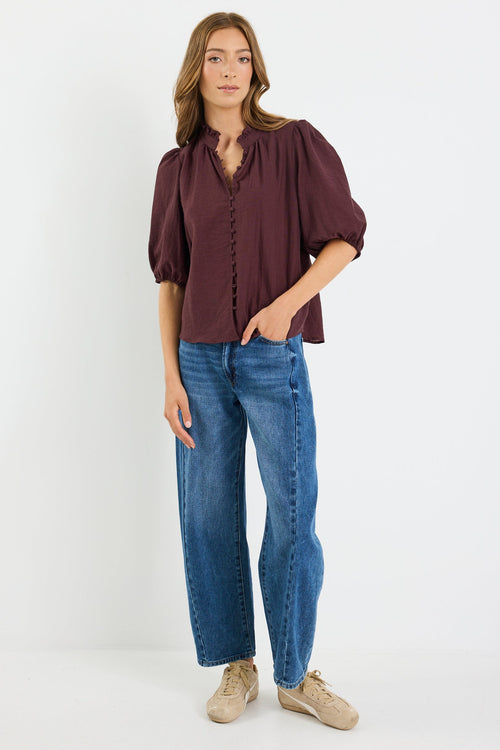 Woman wearing a brown blouse and blue jeans on a white background