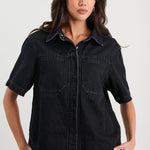 Woman wearing a black denim shirt against a white background