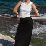 Woman standing on a rocky outcrop by the ocean