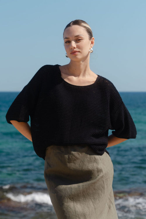 Woman standing on a beach with ocean in the background