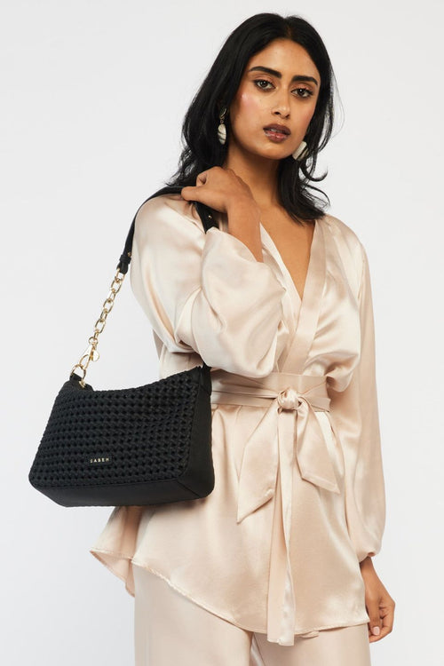 model wears a black shoulder handbag