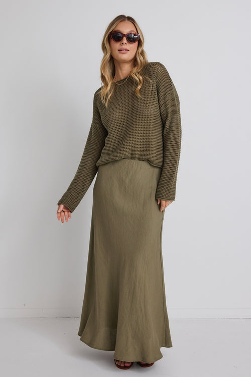 model wears a green knit jumper and a green linen maxi skirt