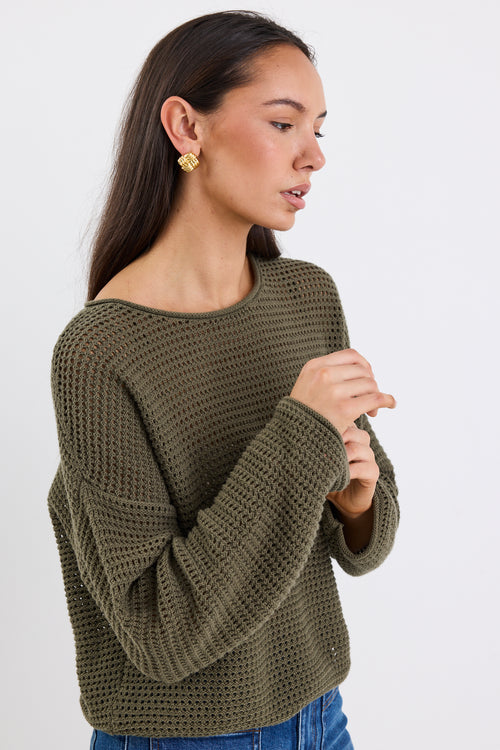 woman wearing a khaki jumper and blue jeans