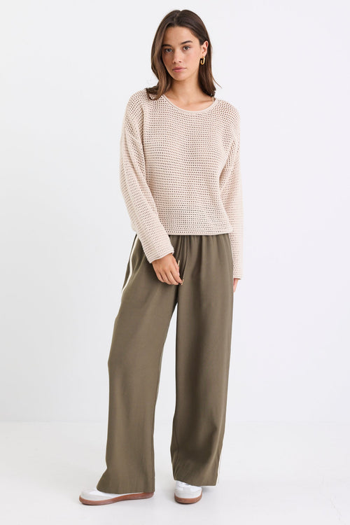 Woman wearing a beige crochet knit and khaki pant