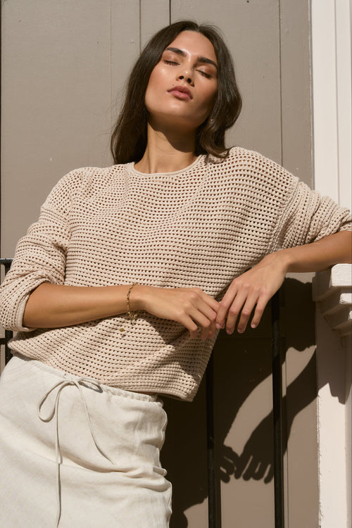 model wears biege knit top